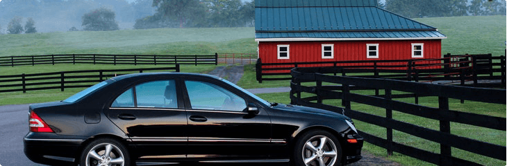 black sedan parked near barn