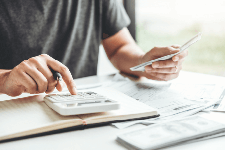 Man typing onto a calculator