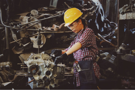 A female mechanic working on an engine.
