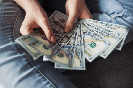 A hand holding cash fanned out