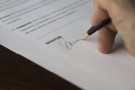 Someone signing a document witha pen