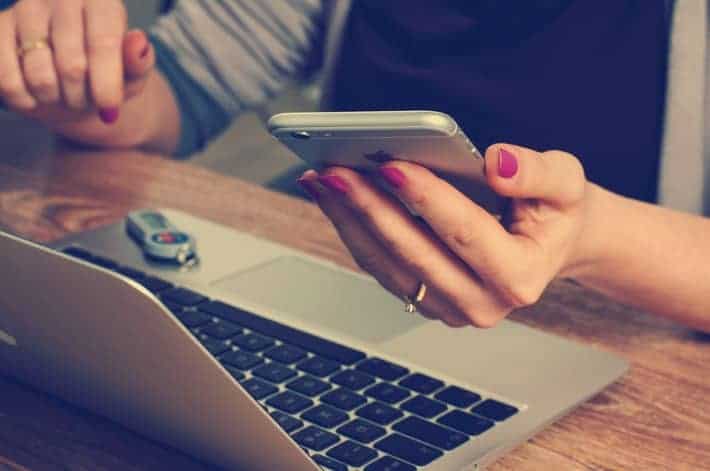 holding cellphone and laptop