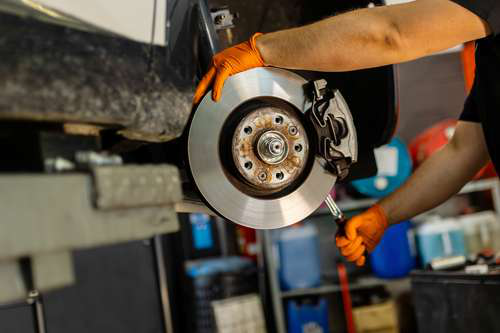 Mechanic repairing car brakes with loan assistance for repair costs