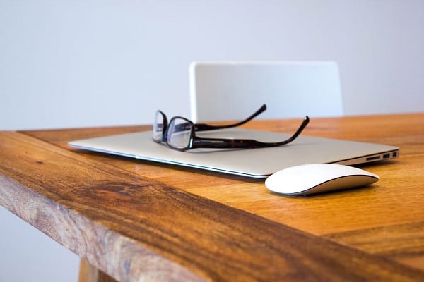 laptop and glasses on wooden table