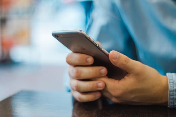 man using cell phone for auto title loan