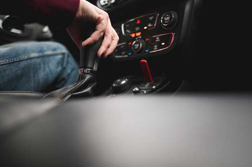 Stick shift in car representing manual transmission and gas savings