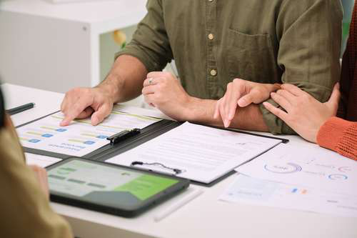 A couple sitting together reviewing documents that outline title loan and auto loan options.
